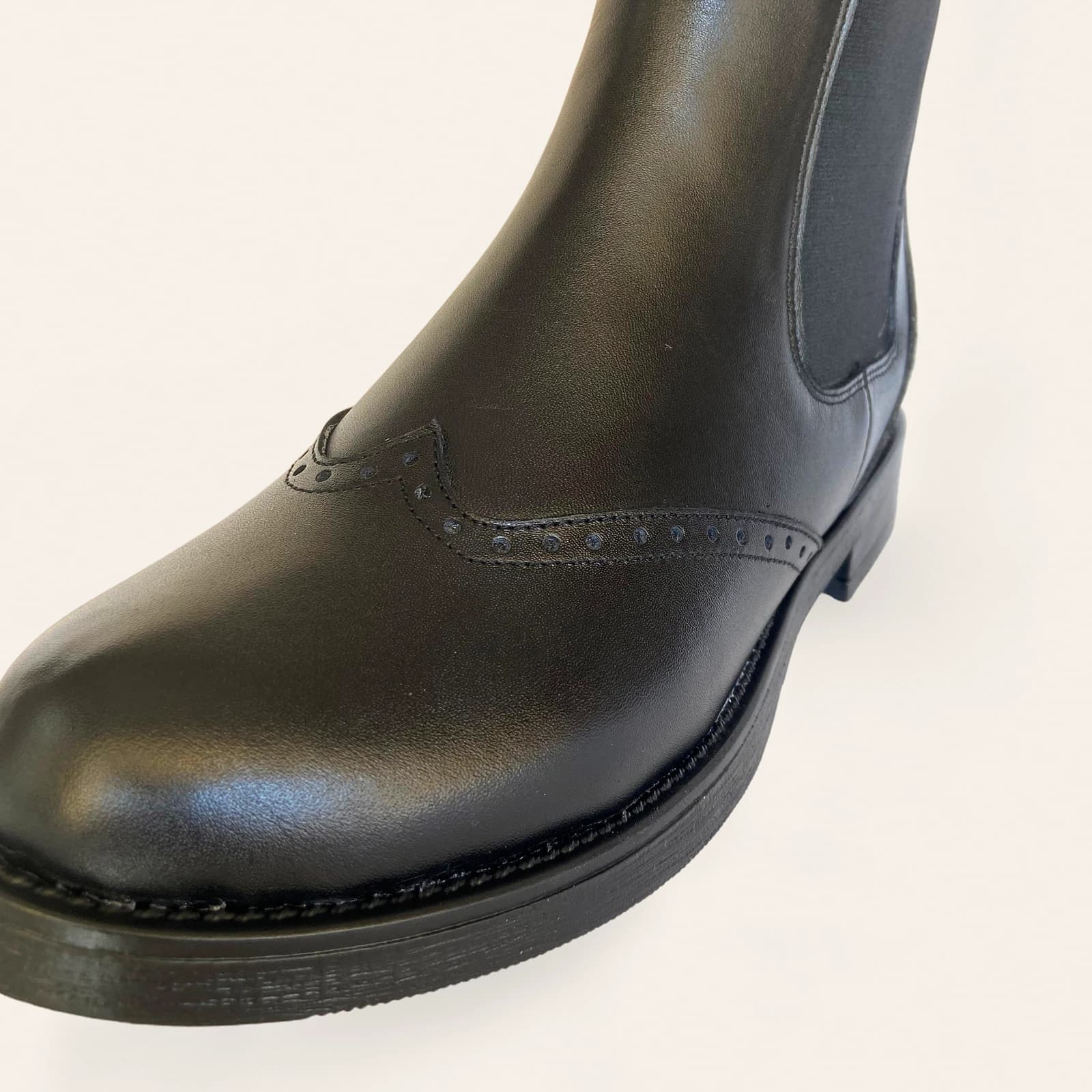 Siyah deri botun zımba desenli burnu, yakın plan